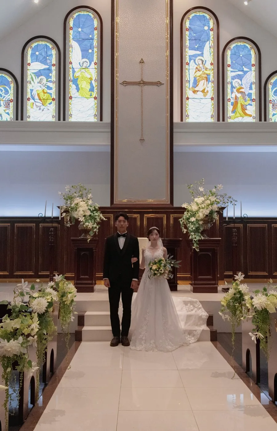 ステンドグラスを背にした新郎新婦