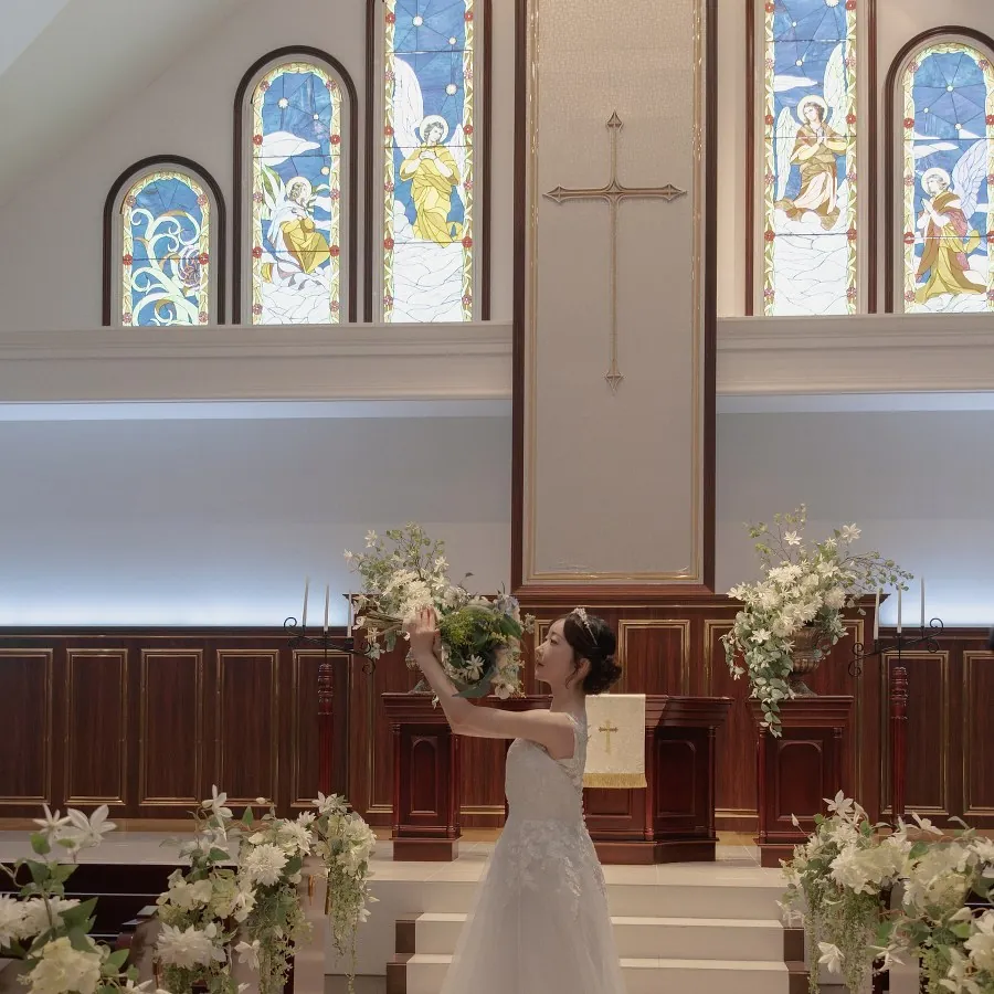 祭壇の花に手を伸ばす新婦