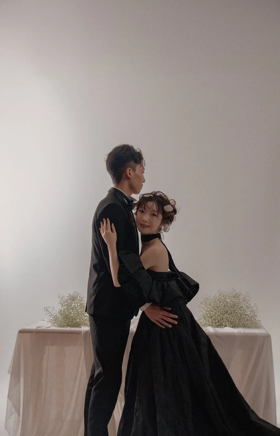 ドライフラワーの前で寄り添う新郎新婦
