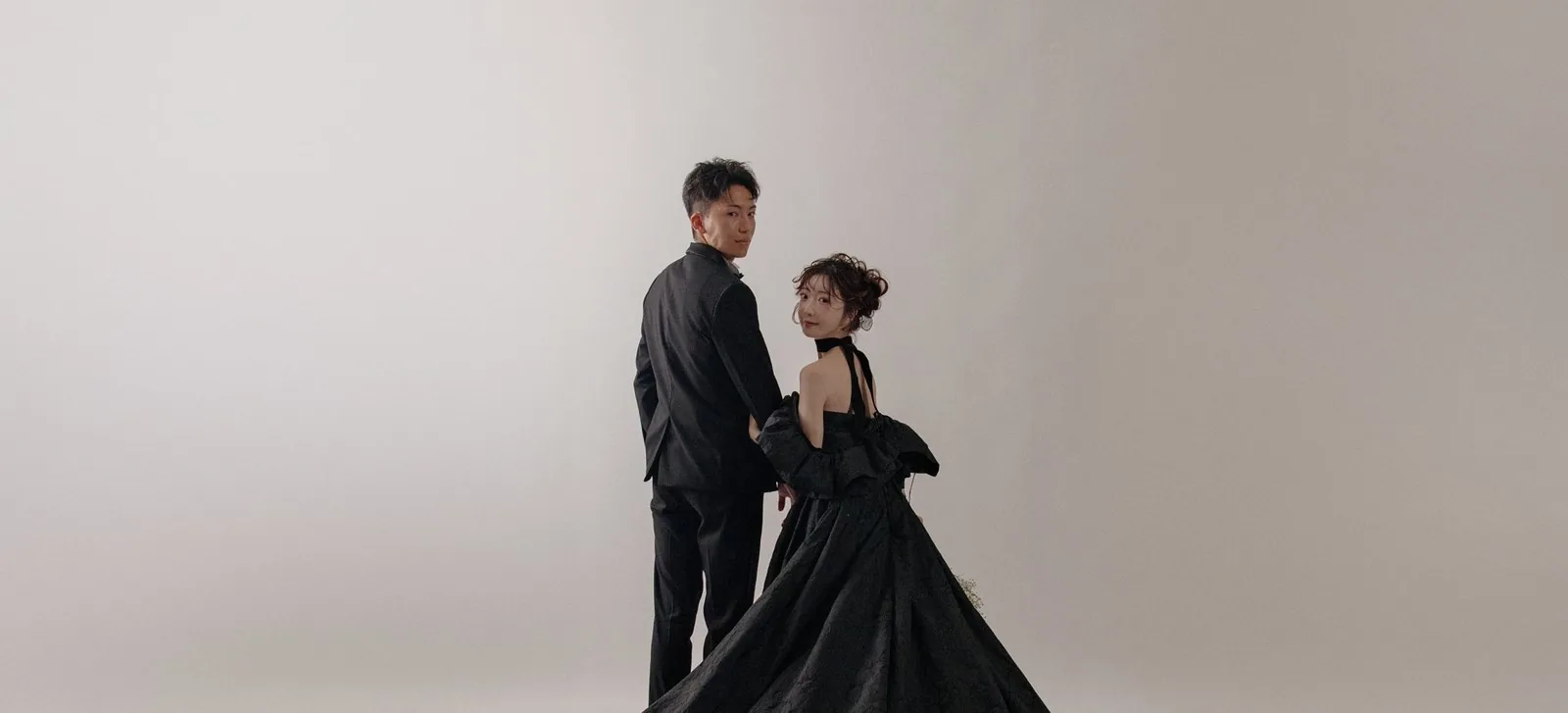 黒いドレスの裾を広げた新郎新婦